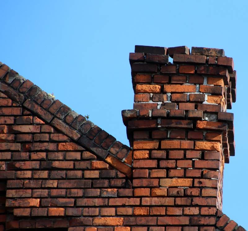Damaged chimney on an Carol Stream home showing cracks and missing mortar